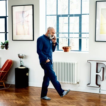 Hipster senior man on cell phone in funky apartment