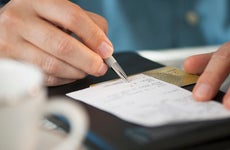 a close up of a person signing a bill