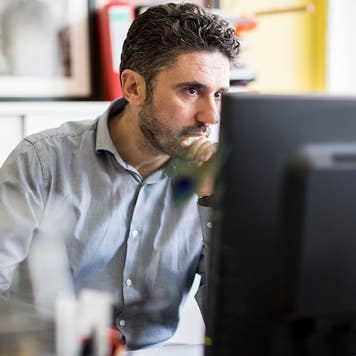 A man looking at a computer screen in an office
