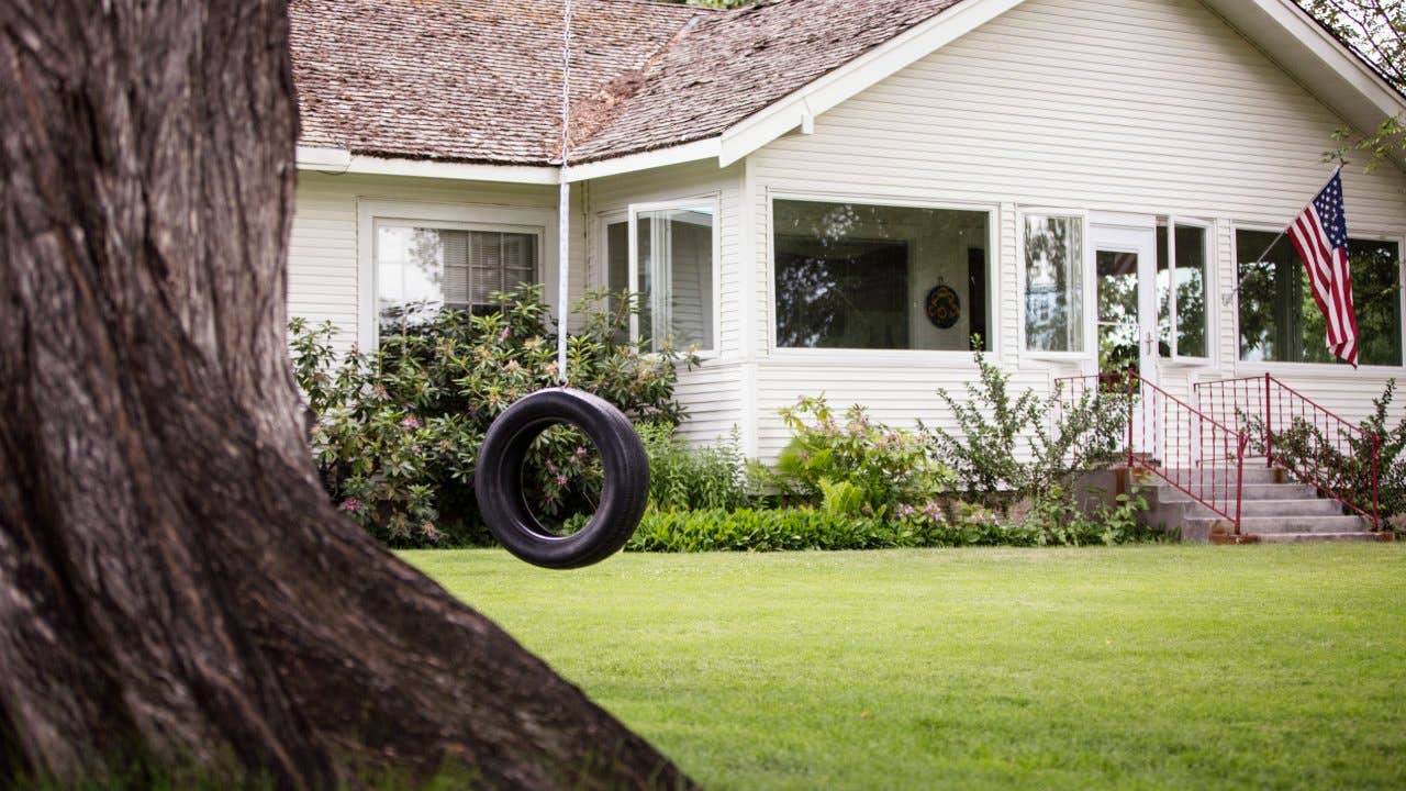 Tire swing hanging on a tree at a house