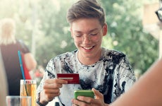 teenage boy using a credit card at a restaurant