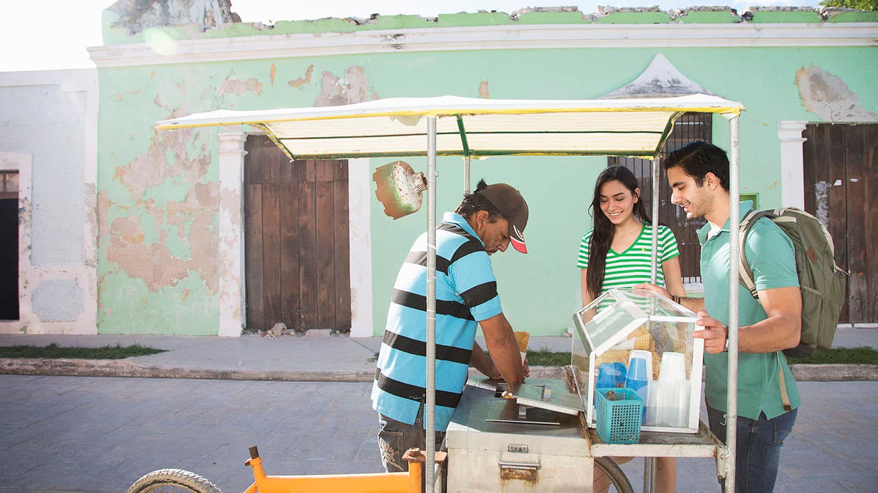 couple buying ice cream from street vendor in Mexico