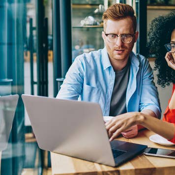 man and woman looking at computer