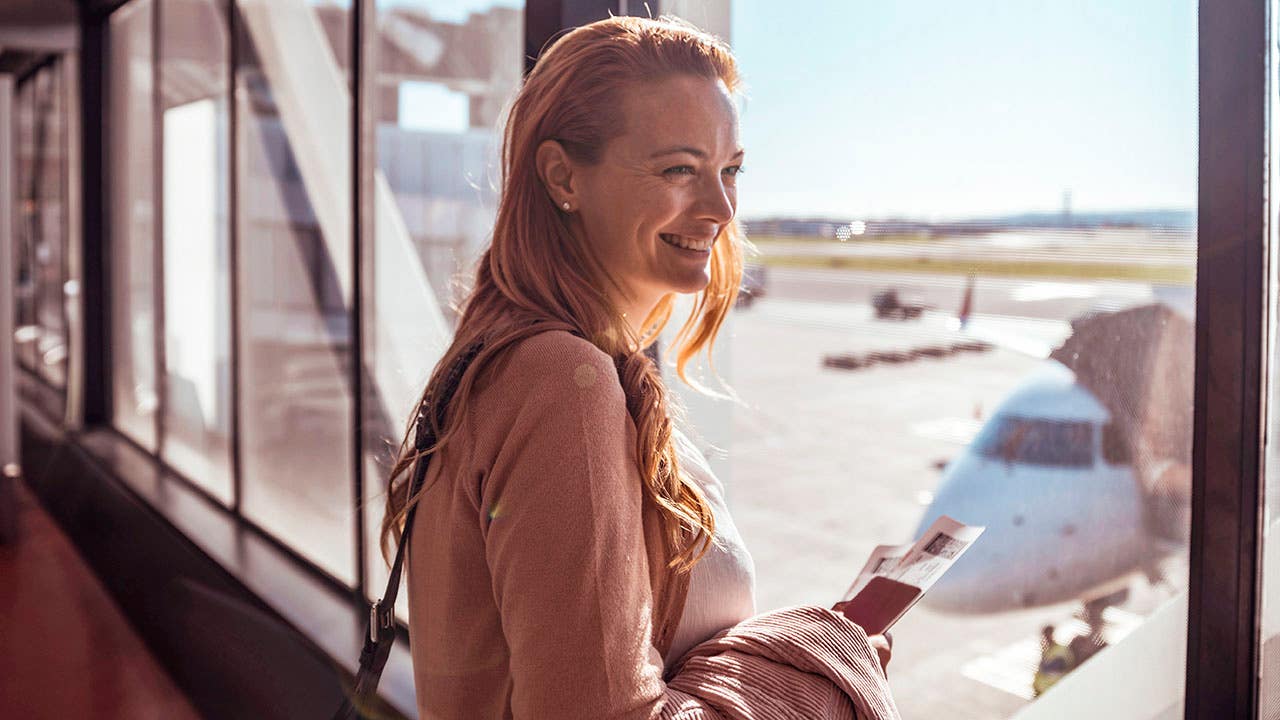 young woman looking out the window at the airport