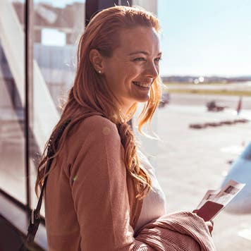 young woman looking out the window at the airport