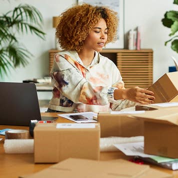 businesswoman taping and packing shipping boxes