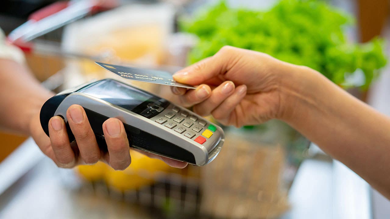 person paying for groceries with a credit card