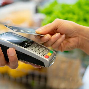 person paying for groceries with a credit card