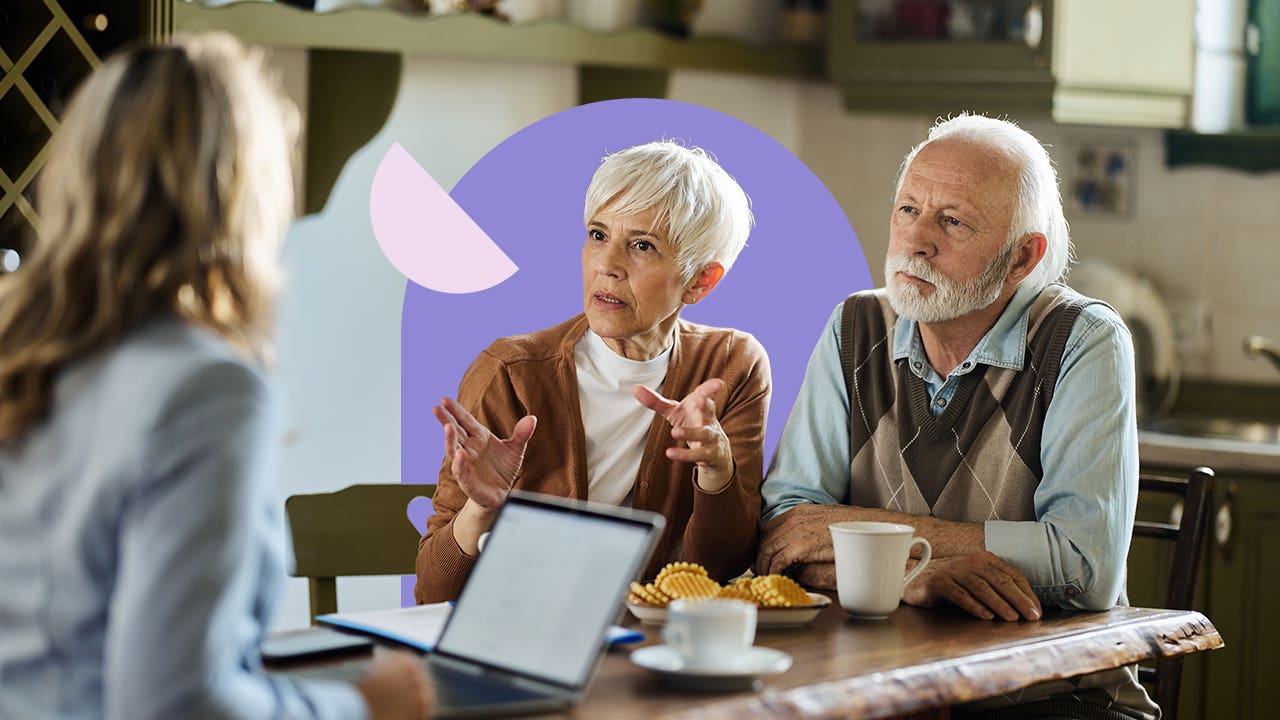 Older couple discussing insurance rates with a representative in a restaurant/cafe.