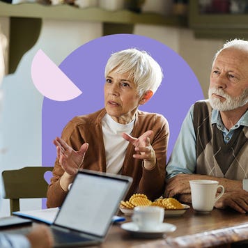 Older couple discussing insurance rates with a representative in a restaurant/cafe.