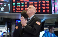 A stock trader seems to pray on the trading floor