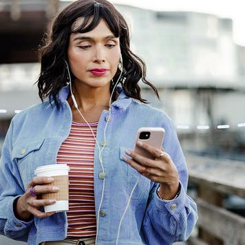 Young person walking and using smart phone