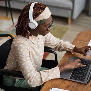 a person with headphone son working on a laptop