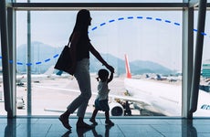 A woman walking in the airport with her young daughter