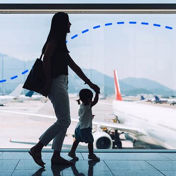 A woman walking in the airport with her young daughter