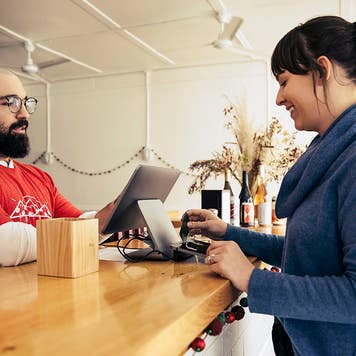 Woman paying with credit card at a pizza shop
