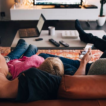 family sitting on couch watching tv