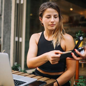 Young girl paying at a cafe
