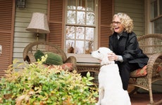 A woman relaxes on her porch with her dog