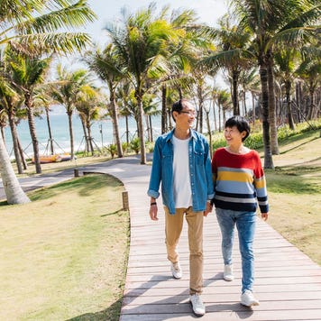 couple walking on path near ocean