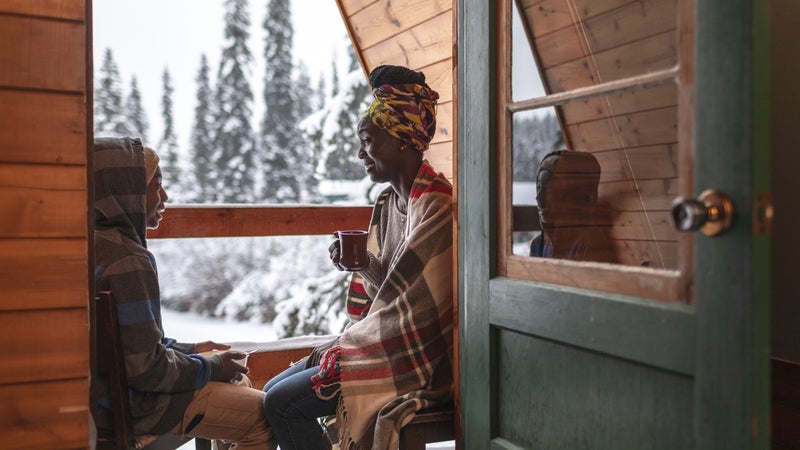 mother and son sitting on cabin balcony in winter