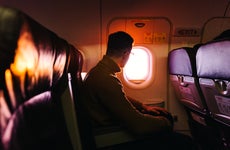 man looking out airplane window