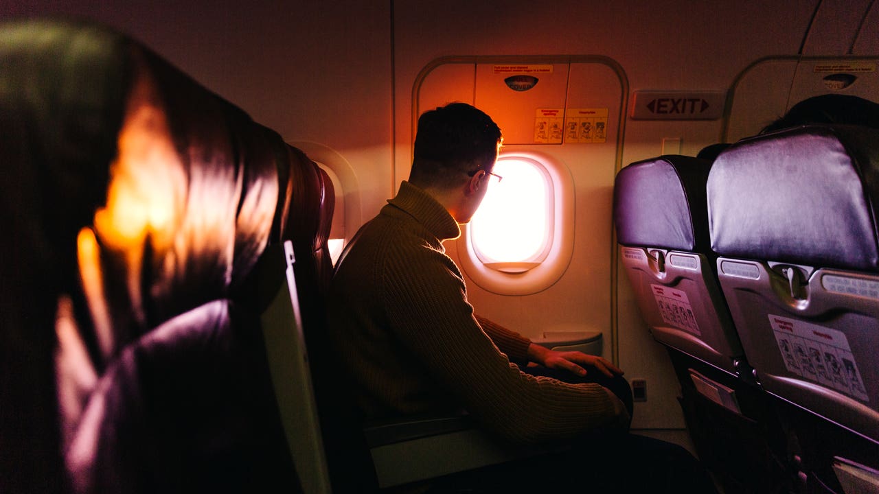 man looking out airplane window