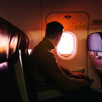 man looking out airplane window