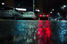 Abstract night city background with red stop lights reflection on wet asphalt