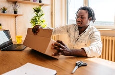 man opening package at desk