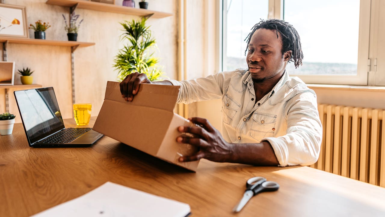 man opening package at desk