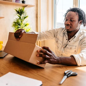 man opening package at desk