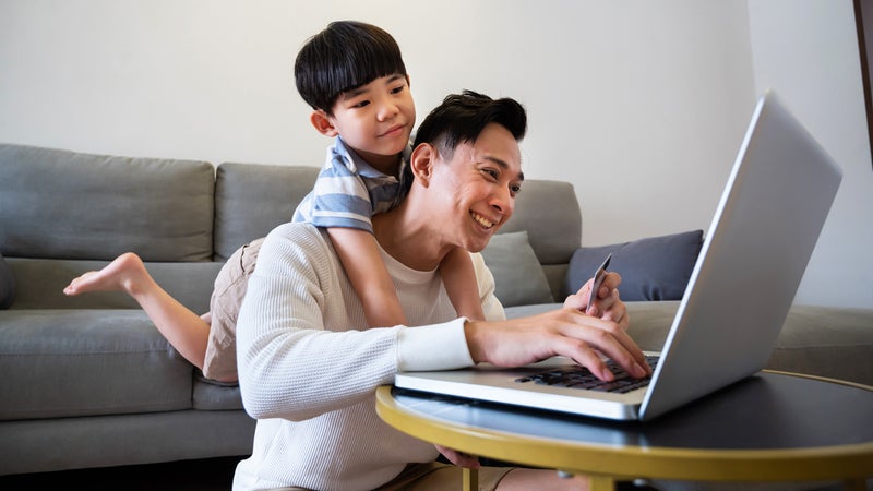 father and son on computer in living room