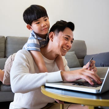 father and son on computer in living room
