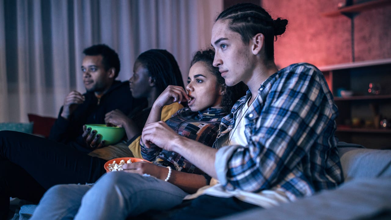 friends watching movie in living room