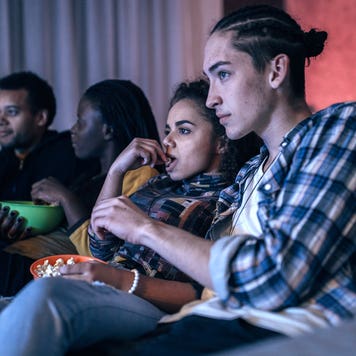 friends watching movie in living room