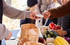 close up of hands paying credit card vendor at farm stand