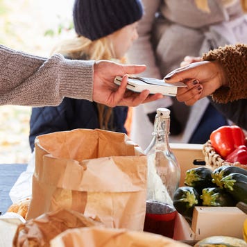 close up of hands paying credit card vendor at farm stand
