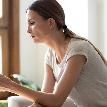 young woman looking at a cell phone at home