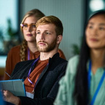Student listens to a presentation at a conference