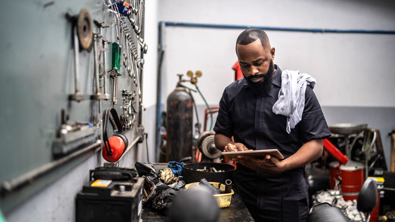 Man working with tablet in auto repair shop