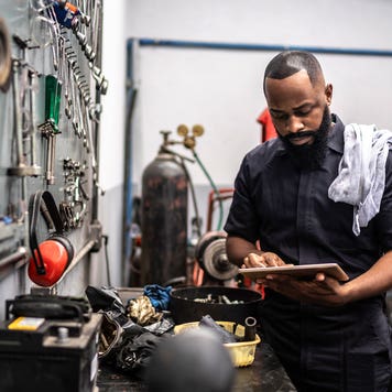 Man working with tablet in auto repair shop