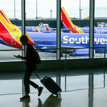 A traveler walks past a Southwest Airlines airplane as it taxies from a gate at Baltimore Washington International Thurgood Marshall Airport on October 11, 2021 in Baltimore, Maryland