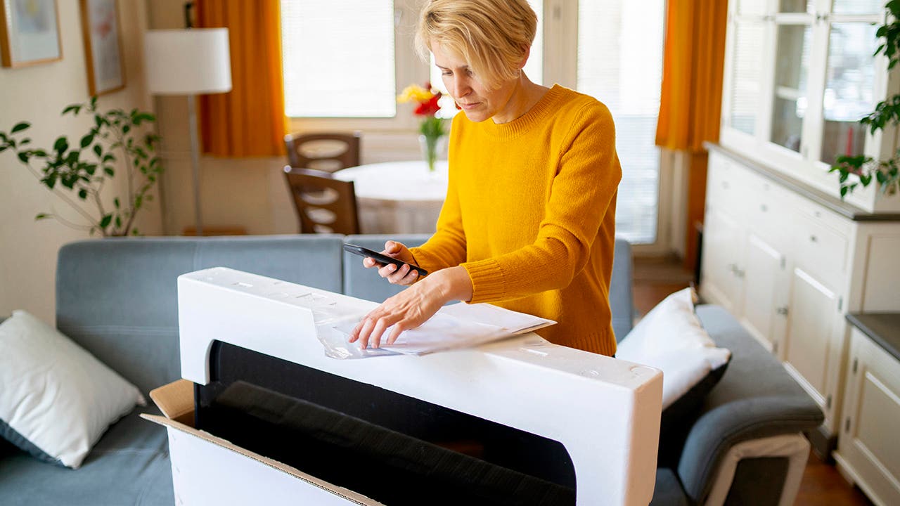 Young woman unboxing a television