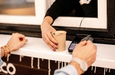 hands of customer paying with credit card to buy coffee