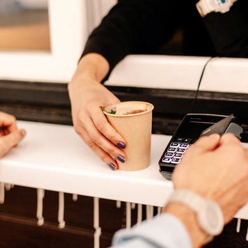 hands of customer paying with credit card to buy coffee