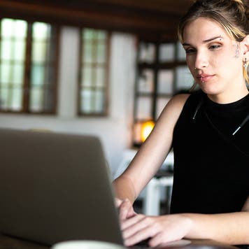 young woman working on laptop at home