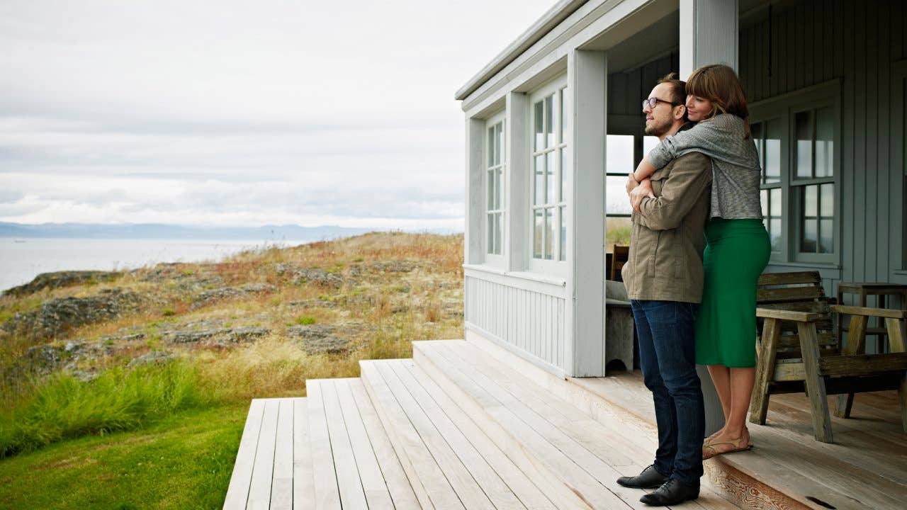 Young couple embracing on porch of home