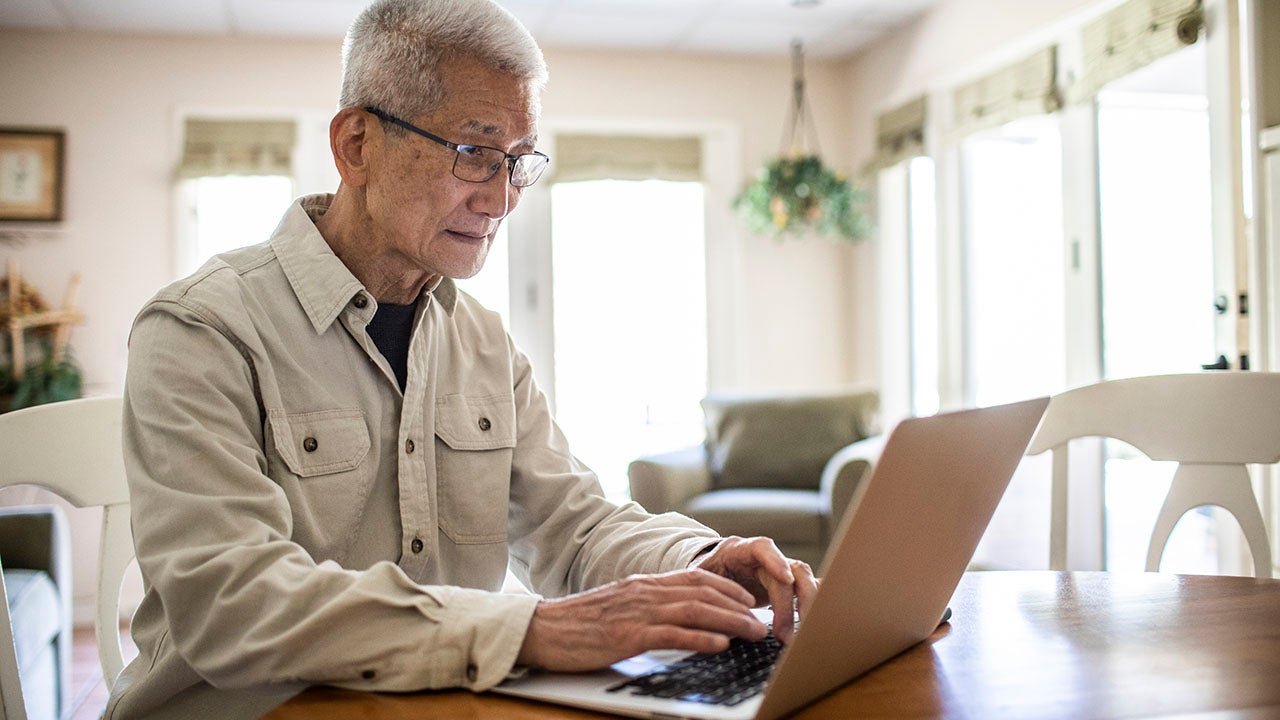 Senior man using laptop computer at home
