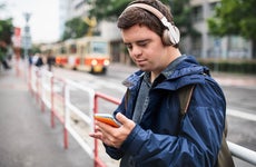 man with Down syndrome using a cell phone outside